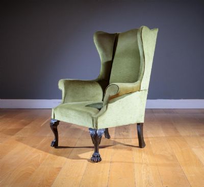 AN UPHOLSTERED WING BACK ARMCHAIR, IN GEORGIAN STYLE at deVeres Auctions