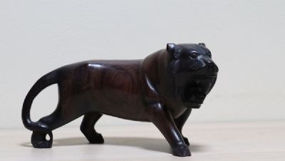 300 by A CHERRYWOOD FIGURE OF A LION  at deVeres Auctions